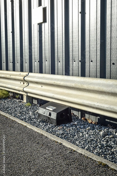 Obraz Black rodent bait and trap station being used outside a building to control rats.