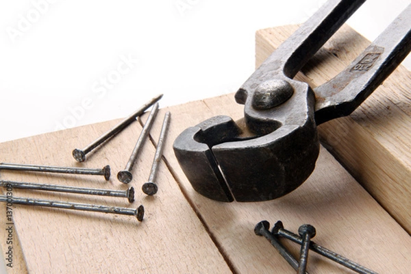 Obraz black pincers and nails on a white background