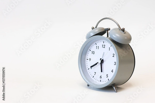 Fototapeta Classic black and white analog alarm clock on a plain white background, showing time clearly, symbolizing punctuality and timeless design.