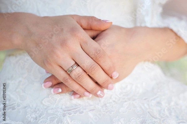 Fototapeta bride hand with a wedding ring on the background of dress