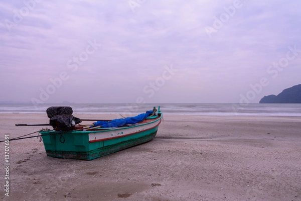 Obraz wooden boat on the beach and couldy sky