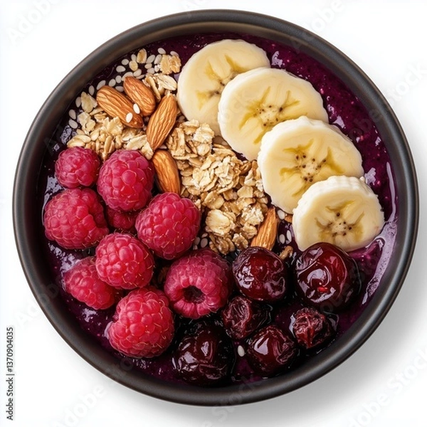 Fototapeta A beautifully presented acai bowl topped with fresh raspberries, cherries, bananas, and crunchy nuts. Separated on white background