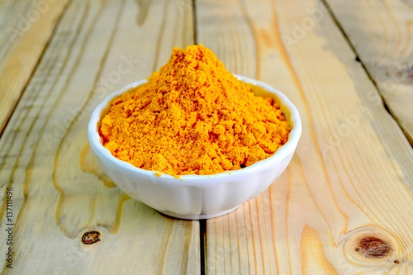 Obraz Tumeric powder in a bowl isolate on wooden background