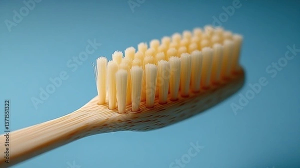 Obraz A single beige toothbrush floats on a light blue background.