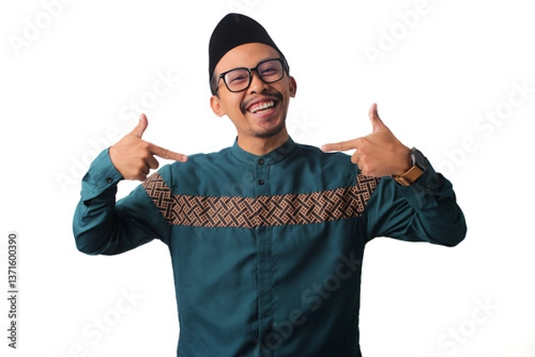 Fototapeta Confident Asian Muslim man pointing to himself with a 'choose me' gesture, looking confidently at the camera, isolated on a white background