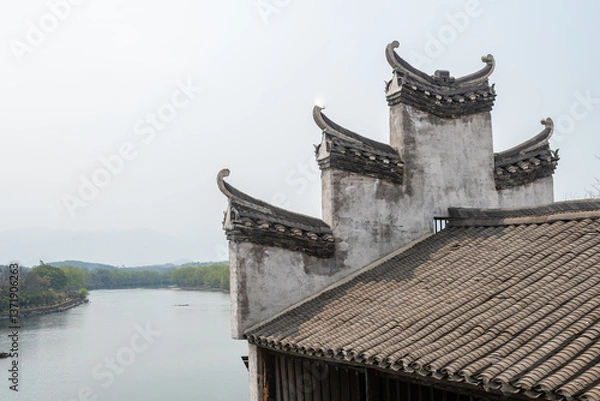 Fototapeta Timeless Harmony: White-Walled Chinese Courtyard House with Elegant Curved Eaves Under Azure Sky – Traditional Architectural Poetry