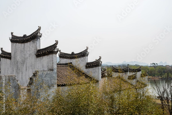 Fototapeta Timeless Harmony: White-Walled Chinese Courtyard House with Elegant Curved Eaves Under Azure Sky – Traditional Architectural Poetry