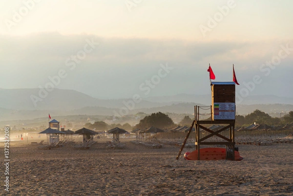 Fototapeta Empty beach with a red flag warning of big waves, sunny summer day