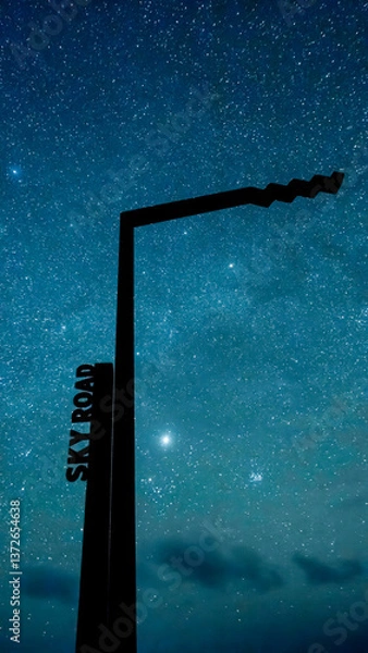 Fototapeta Wild Atlantic Way signpost silhouetted against star-filled sky on Sky Road during new moon.