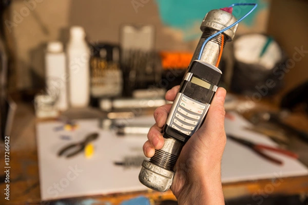 Fototapeta Pipe bomb in hand with workshop in background