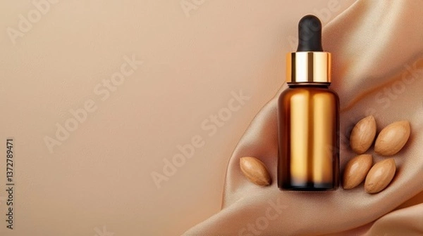 Obraz Luxurious golden argan oil in a dropper bottle, surrounded by argan nuts and soft fabric