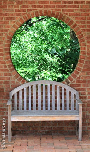 Obraz Trees through round window and wood bench