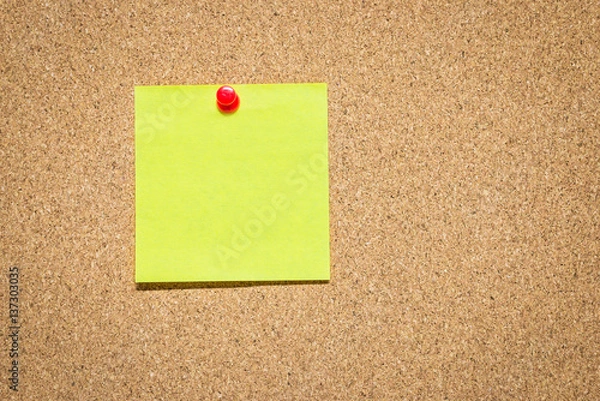 Fototapeta Yellow reminder sticky note on cork board, empty space for text