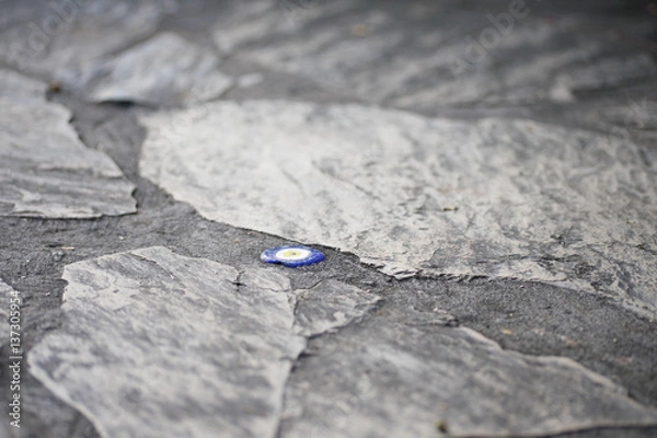 Obraz The evil eye bead inside the concrete of rocky road