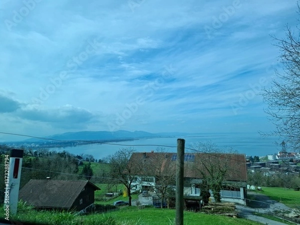 Fototapeta View of a house in the countryside.  Pfänder, Liechtenstein. Showcasing Bodensee, the alps and other mountains of 4 countries (Germany, Austria, Liechtenstein and Switzerland) 
