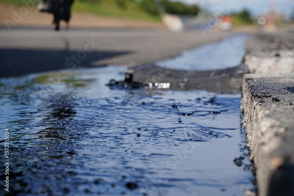 Fototapeta Low-angle detailed shot of hot bitumen coating on fresh asphalt, showcasing texture and close-up details at highway construction site