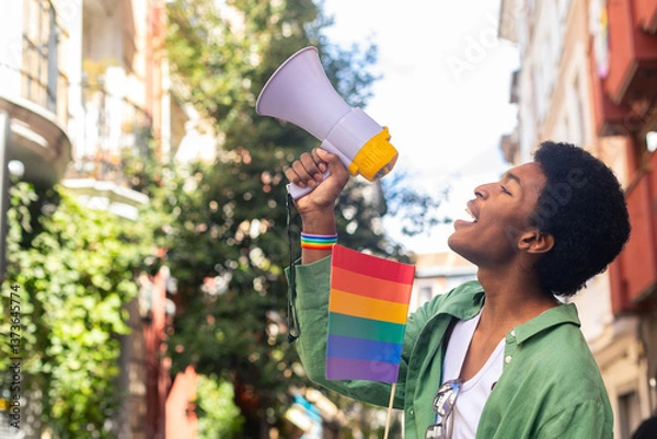 Obraz Young activist shouting with megaphone at pride parade promoting lgbtq plus rights