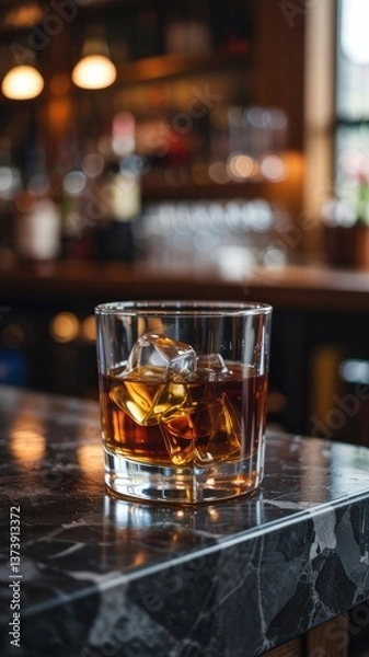 Fototapeta Classic whiskey cocktail served on the rocks at a cozy bar with a warm ambiance in the evening