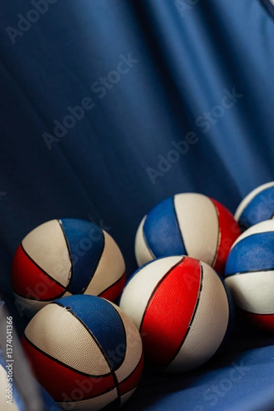 Fototapeta red white and blue mini basketballs on blue fabric as part of arcade basketball game, roomy for copy