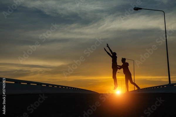 Fototapeta silhouette couples Jumping at sunset
