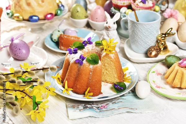 Obraz Easter table with traditional ring cake with fresh flowers on the top