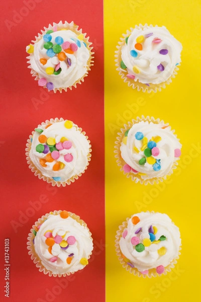 Obraz Delicious cupcakes on split red and yellow background