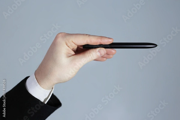 Obraz Business hand pointing on a gray background. A pen