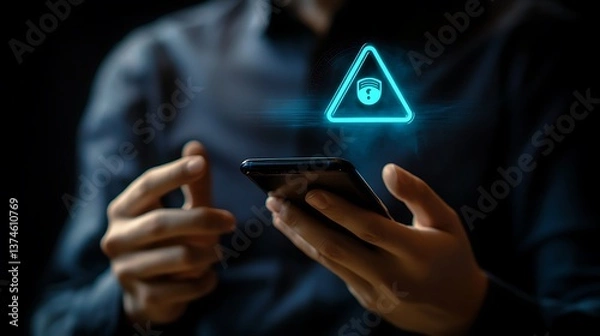 Fototapeta Man Holding Smartphone with Glowing Alert Triangle Icon on Screen in Dark Lighting