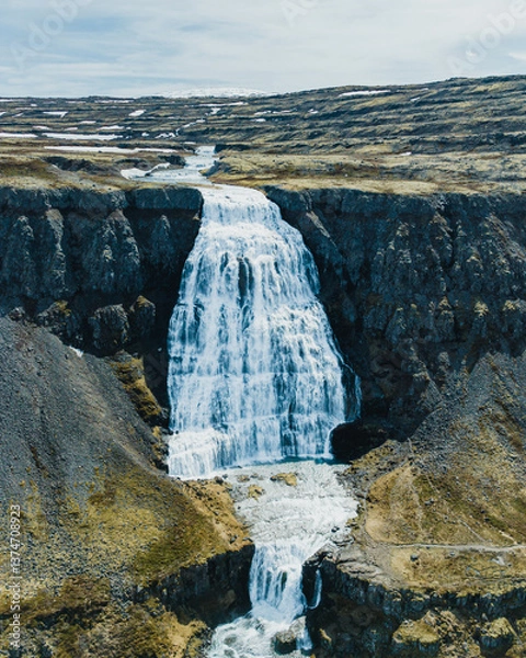 Fototapeta Dynjandi waterfall cascading through rugged cliffs in Westfjords, Iceland..