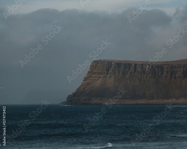 Fototapeta Moody coastal cliffs rise from the sea in Patreksfjordur, Westfjords, Iceland...