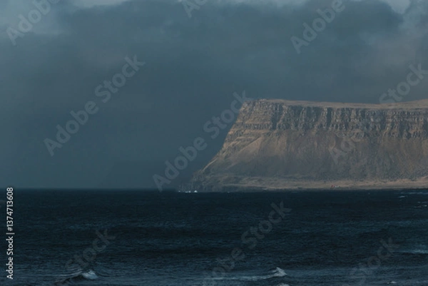 Fototapeta Moody coastal cliffs rise from the sea in Patreksfjordur, Westfjords, Iceland...