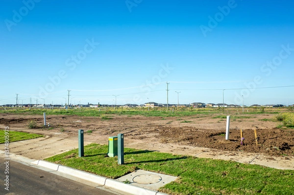 Fototapeta Undeveloped plot of land or construction site in Tarneit, Australia. A vacant lot is prepared for future construction or development in an outer suburb of Melbourne