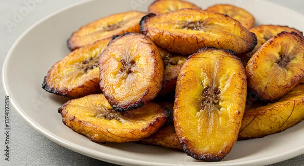 Fototapeta Golden Perfection: A Plateful of Delightful and Crispy Fried Plantains Treat
