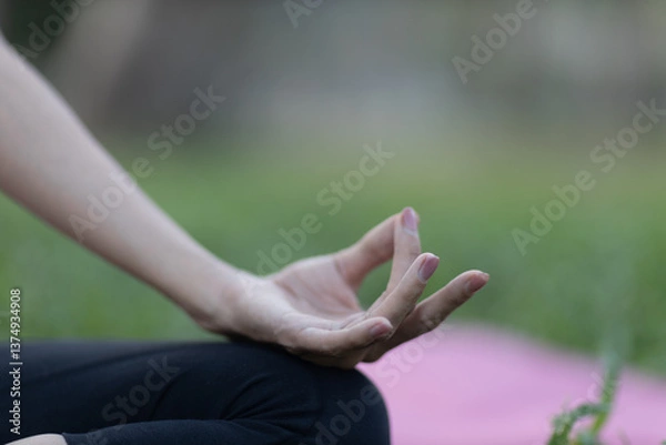 Fototapeta A enthusiastic Asian sports woman stopped after exercising at the garden, sitting on a exercise mat, inhaling deeply by closing her eyes. Sports and exercise regularly Health and health