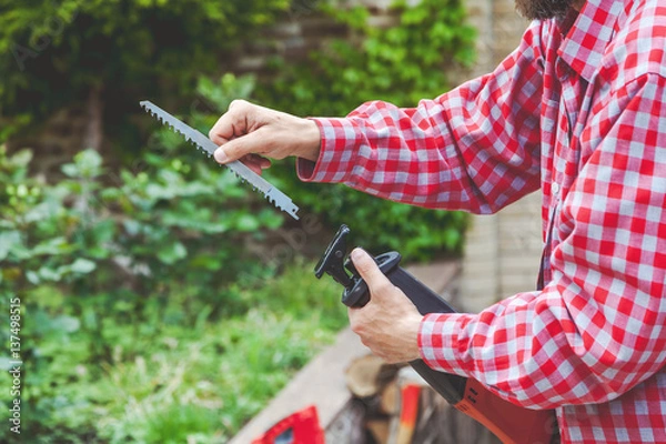 Obraz man in plaid shirt sawing inserts in tool
