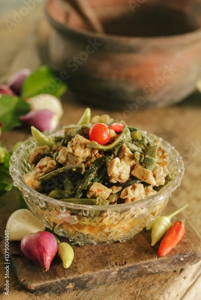 Fototapeta Stir-fried long beans mixed with tempeh in bowl. Tumis kacang panjang campur tempe. Indonesian traditional cuisine. Selective focus.