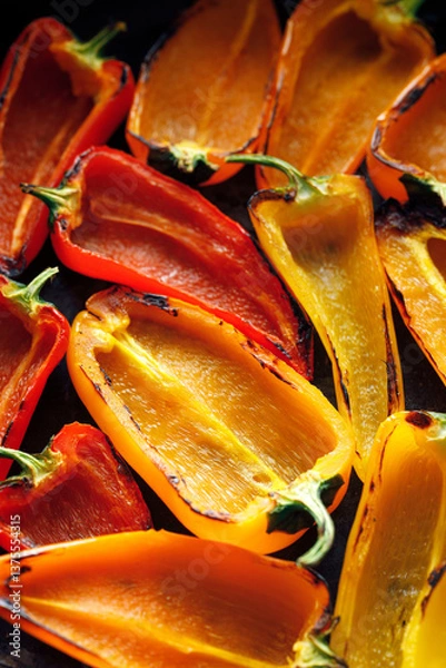 Obraz Grilled colorful peppers on a black background, focus on the middle