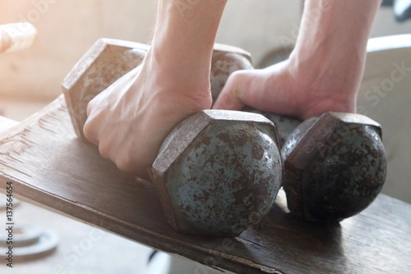 Obraz hands is Lifting dumbbell with orange light..