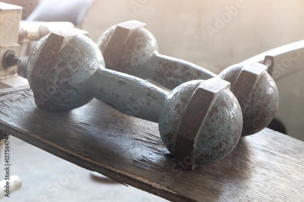 Obraz two old dumbbell on table with orange light..
