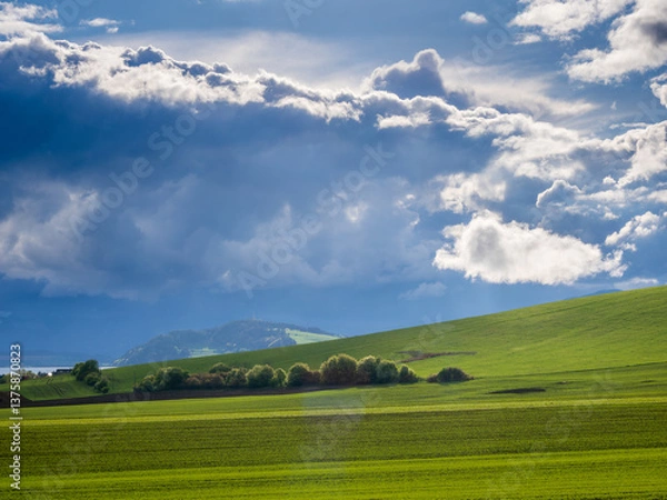 Obraz Mountain landscape. A view of the green hills with storm clouds looming over them.