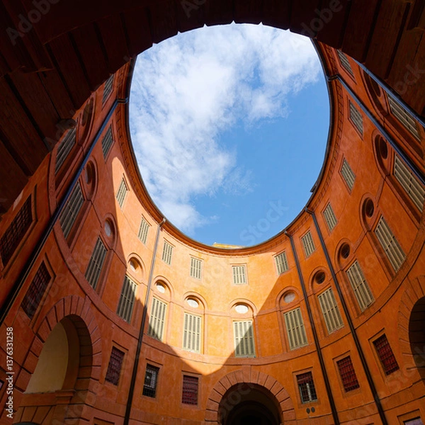Obraz Rotonda Foschini, an elliptical courtyard in Ferrara, Italy. The courtyard's design creates a sense of symmetry and harmony, with the open sky visible above, adding to its enchanting atmosphere.