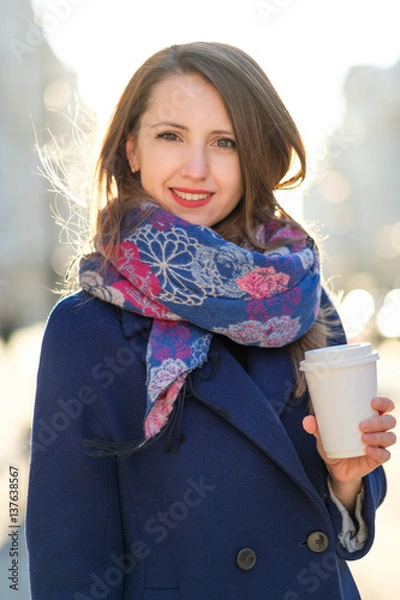 Obraz young woman on the street with a cup of coffee in hand