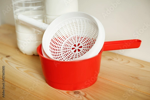 Obraz Plastic equipment for making soft cheese and cottage cheese at home. A white uniform, a red ladle.