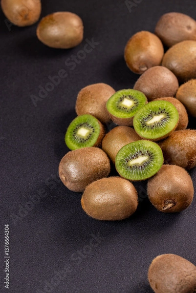 Fototapeta Fresh kiwi fruits displayed on a dark background