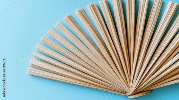 Fototapeta Natural rubber twist ties in a fanned pattern on a pastel blue background