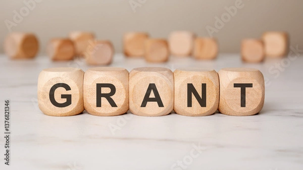 Fototapeta Wooden blocks spelling GRANT on a desk, symbolizing financial support, funding, and investment.