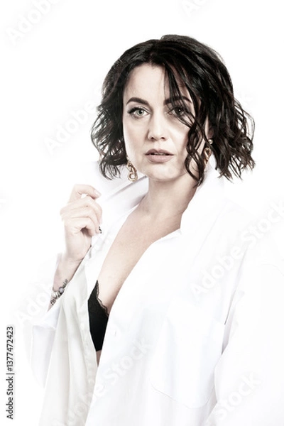 Obraz Portrait of a woman with dark hair, dressed in a white shirt, done in a high key.