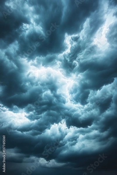 Fototapeta Dramatic stormy sky with dark clouds and bright light shining through creating a powerful atmosphere for weather photography