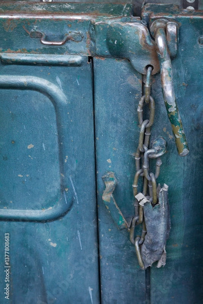 Obraz A chain is hanging from a lock on a blue object