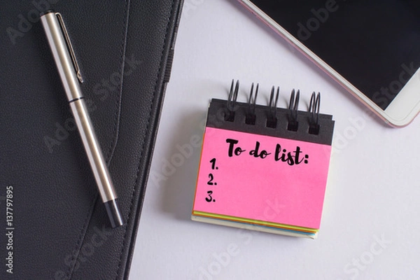 Fototapeta "To do list" words on pink sticky notes with fountain pen, diary and smartphone on white background - business and finance concept